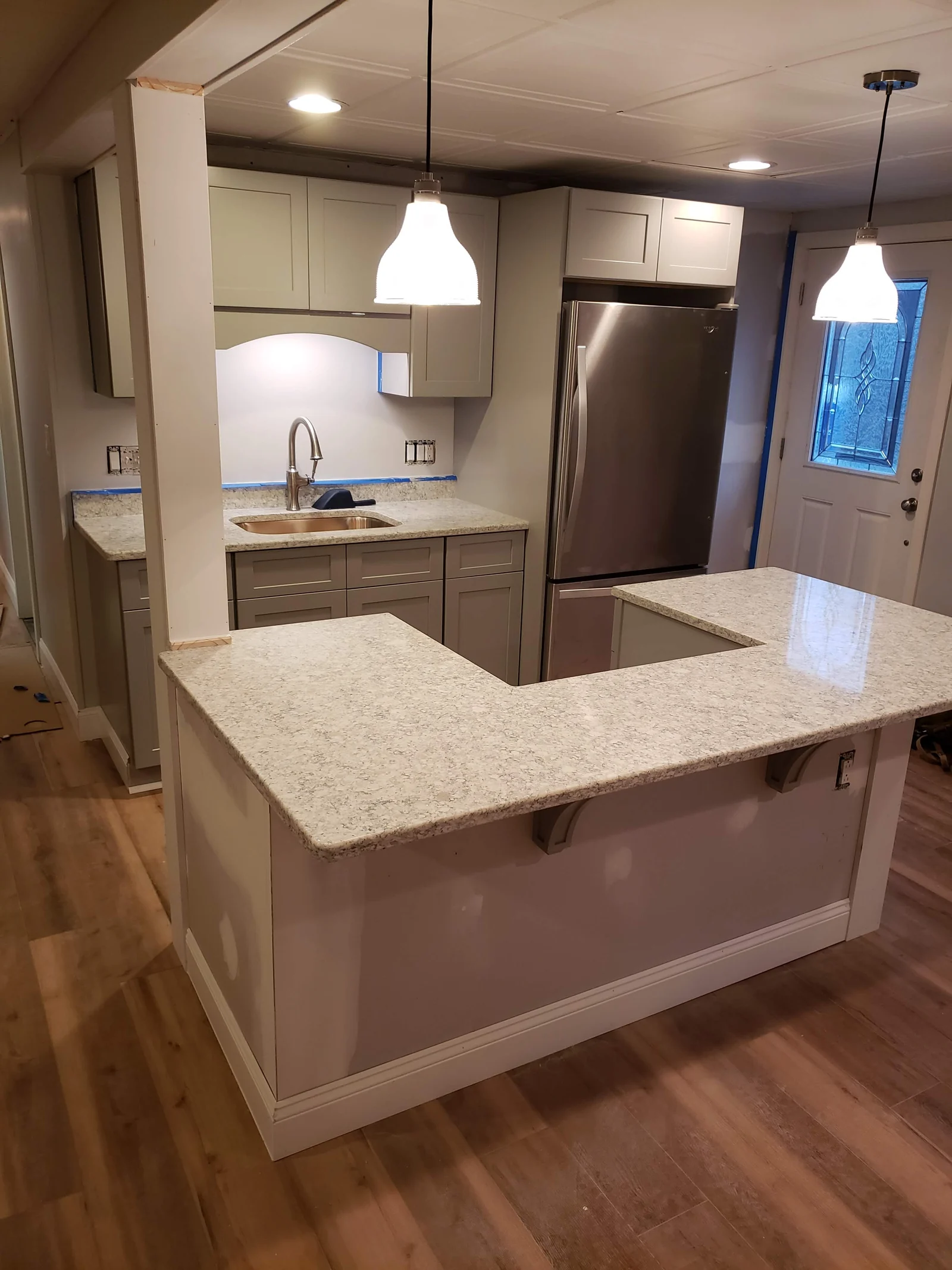 Kitchen island, cabinets, counter, and pendant lighting